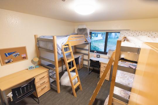 Triple dorm room with three beds and three desks