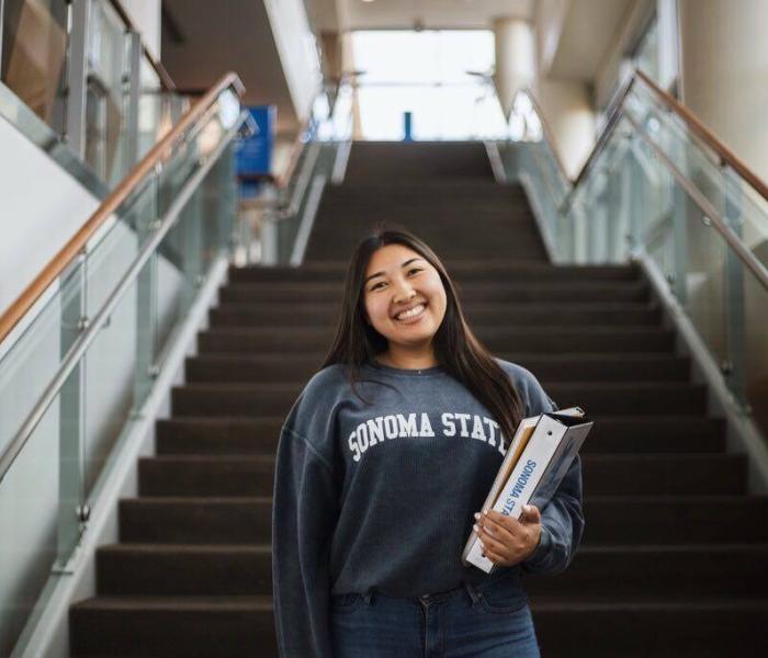 Student holding textbooks and wearing an SSU sweatshirt