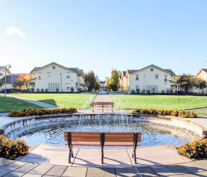 Fountain and benches with Tuscany buildings in the background