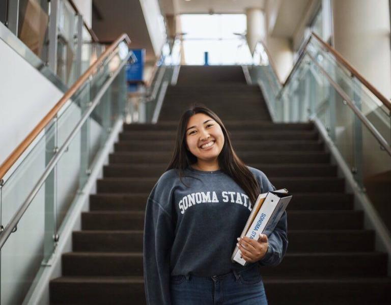 Student holding textbooks and wearing an SSU sweatshirt