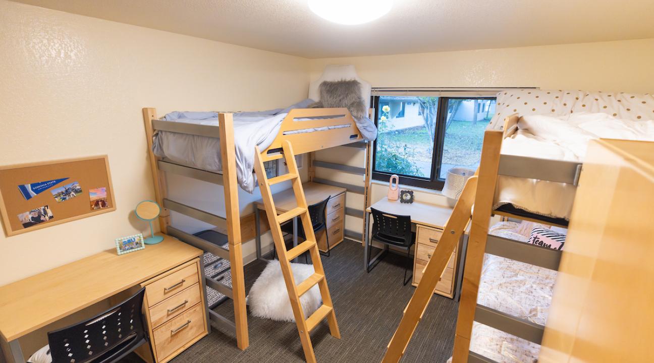 Triple dorm room with three beds and three desks