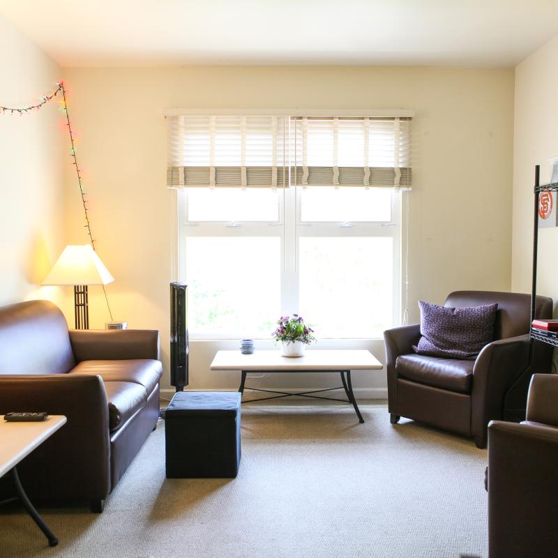 interior of dorm room with white walls and large windows