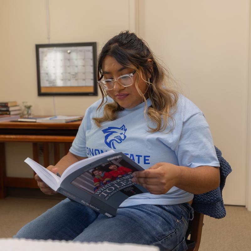 student reading textbook in dorm