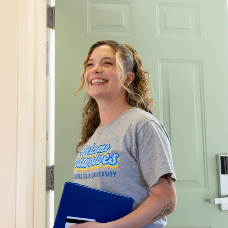 student smiling outside of dorm