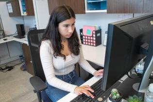 Student on computer sitting at a table 