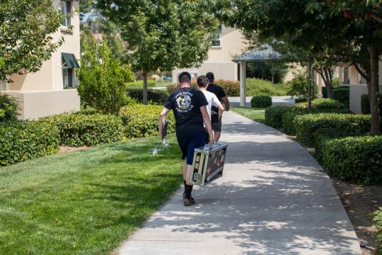 students and parents carrying boxes 