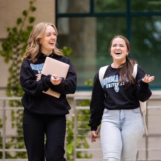 two students walking and smiling and laughing