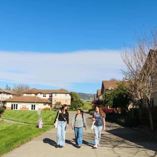 three students walking across campus