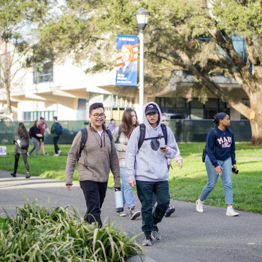 students walking across campus smiling