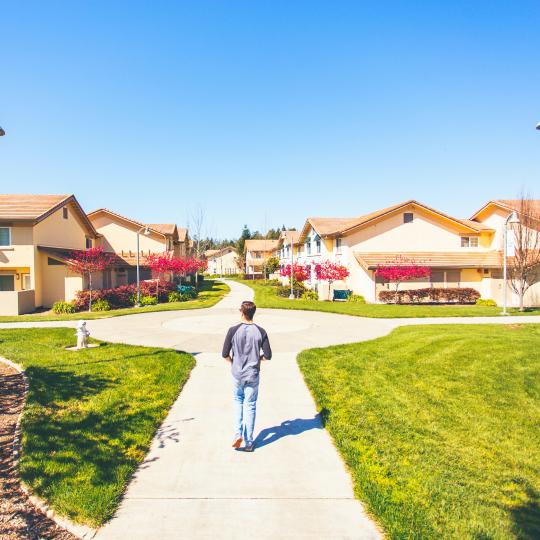 student walking on campus green