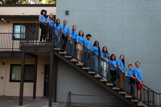 the RA student staff wearing blue shirts lined up along a staircase