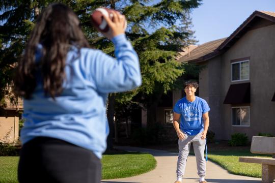 Kent standing waiting for a student to throw a football his way