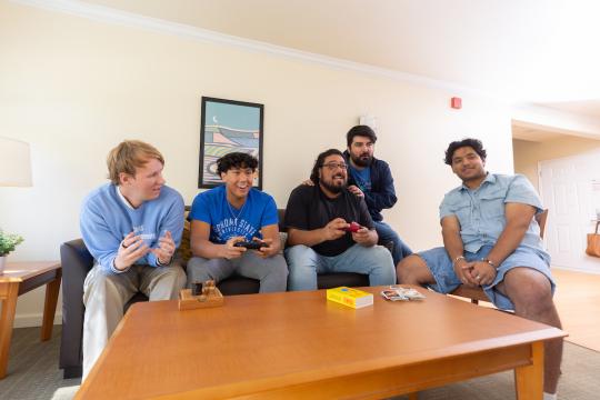 Group of students socializing in a living room