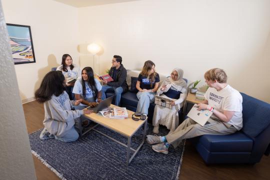 Students sitting in a living room socializing