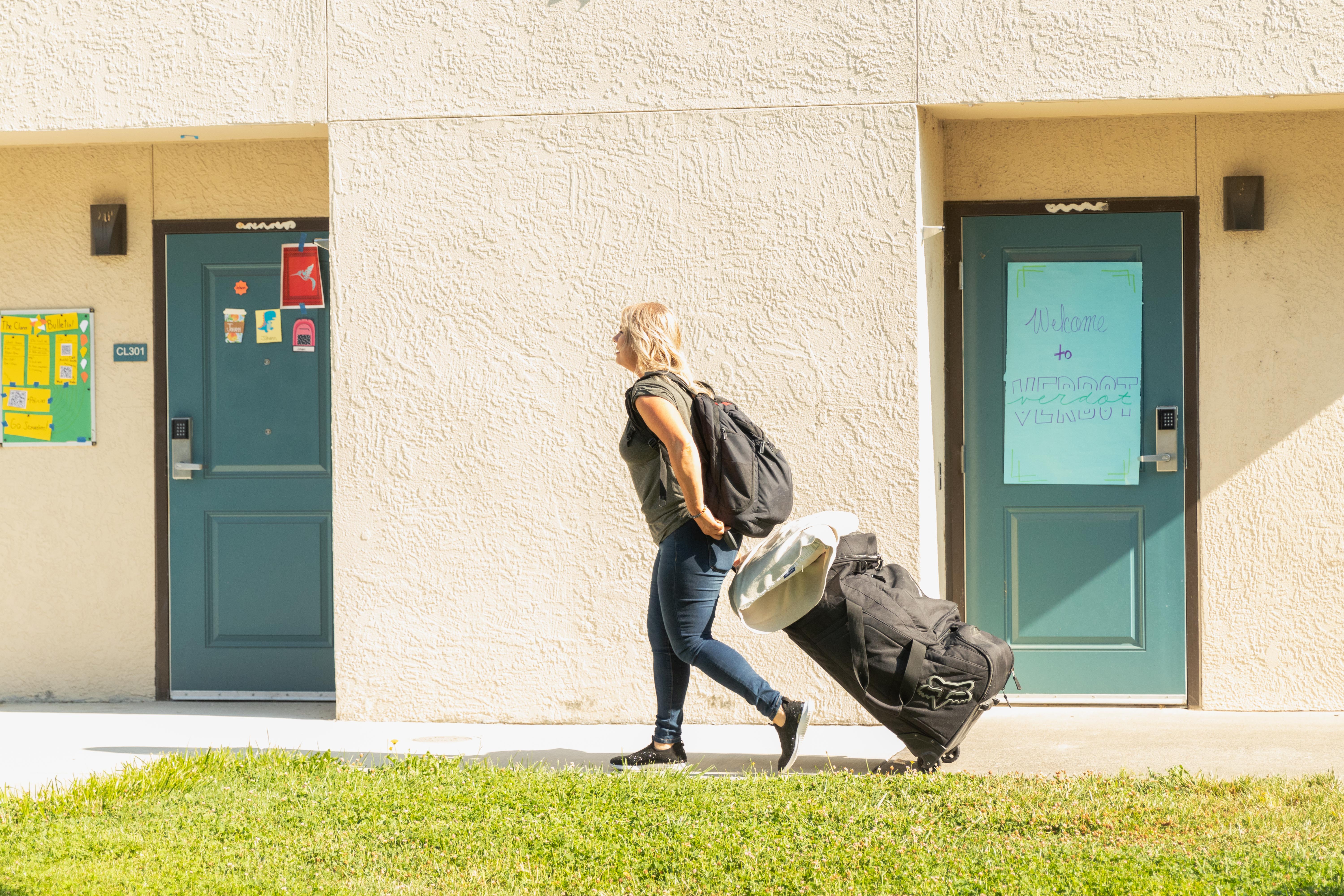 Student caring suitcase walking to room to move in